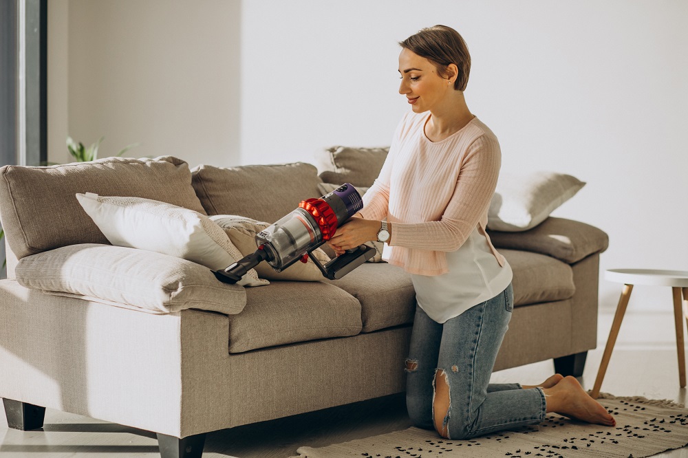 Ilustrasi seseorang menggunakan vacuum cleaner